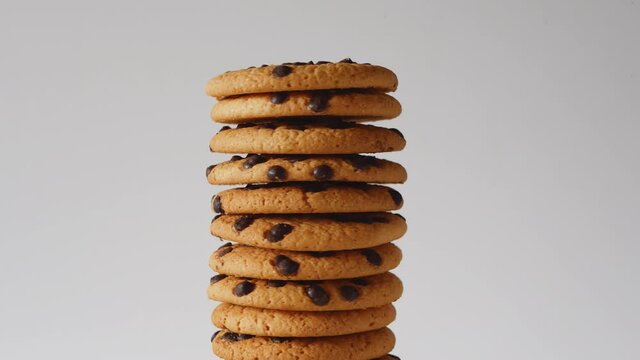 A stack of chocolate chip cookies rotate on a light background. American cookies close-up