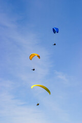Paragliders flying one above the other in the sky