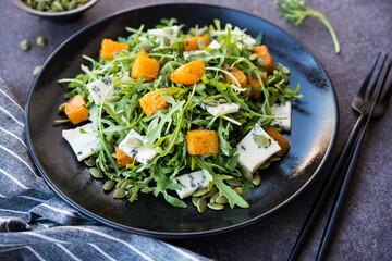 Arugula, blue cheese, pumpkin, pumpkin seeds, salad in a plate