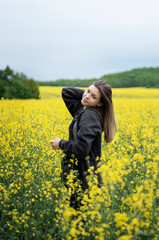 Fototapeta premium Young girl on yellow rapeseed field