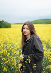 Fototapeta premium Young girl on yellow rapeseed field