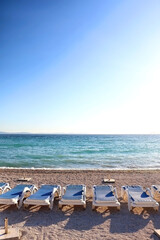 Fototapeta na wymiar Deck chairs arranged on a beautiful beach near Split, Croatia. Selective focus.