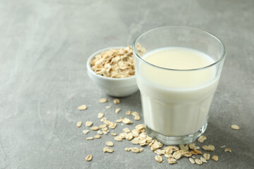 Glass of milk and cereals on gray textured background