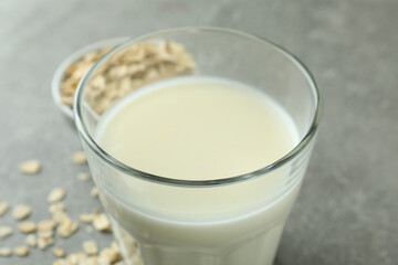 Glass of milk and cereals on gray textured background