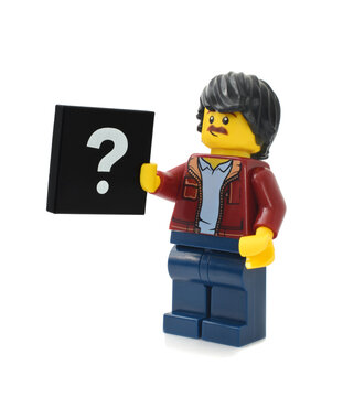 Lego minifigure of man with black plate of question-mark. Editorial illustrative image of choice.