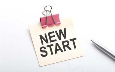 NEW START text on sticker with pen on white background