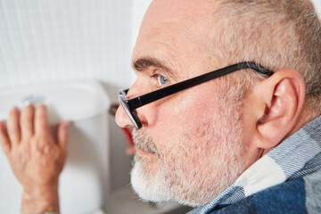 Fototapeta premium Handwerker bei Montage oder Reparatur vom Spülkasten
