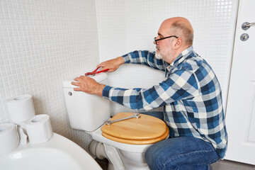 Handwerker montiert den Sp&uuml;lkasten vom WC