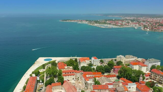Zadar, Croatia - 4K flying over sideways at the old town of Zadar, a famous tourist attraction in Croatia, Dalmatia region on a bright summer day with blue sky and red rooftops