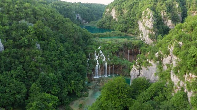 Plitvice, Croatia - 4K flying over the beautiful waterfalls of Plitvice Lakes in Plitvice National Park on a bright summer morning. Green foliage, turquoise water, flying forward and upward