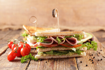 sliced club sandwich on wood background