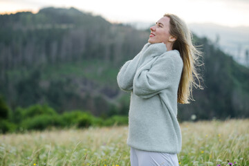 happy woman enjoying sunset stay on the green grass on the forest peak of mountain. Fresh air, Travel, Summer, Fall, Holidays, Journey, Trip, Lifestyle.