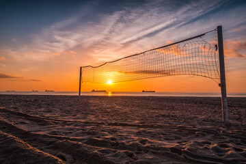 Volleyball net and sunrise on the beach
