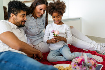 People family holiday concept Happy little girl giving flowers to mother in bed at home