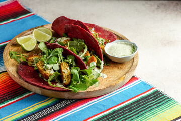 Mexican national food - taco wheat beetroot tortilla with vegan chickpea balls and vegetables