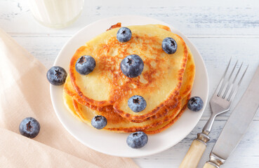 pancakes with blueberries on a plate on a light
