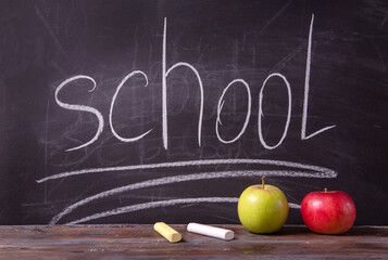 chalk, 2 apples on the table, inscription school on a black blackboard,