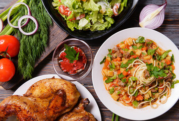 caucasian cuisine, tobacco chicken, noodles with meat and vegetables, tomato, onion and herbs, salad,