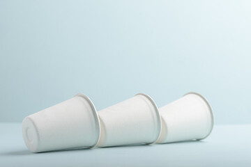 Biodegradable paper cup on blue background. Eco-friendly sustainable products concept zero waste lifestyle. Minimalism simple and copy space