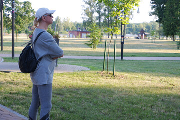 A tourist girl in a white cap inspects an unfamiliar area.