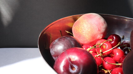 cherries, peaches and plums in a plate