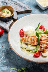 Healthy caesar salad with grilled chicken, cheese and croutons, quail eggs and cherry tomatoes, Delicious balanced food concept, vertical image. top view. place for text