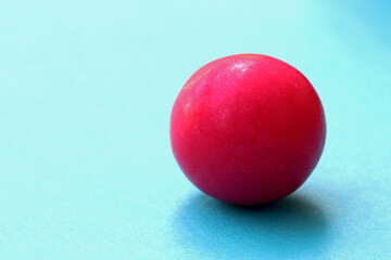 red gum ball on blue background