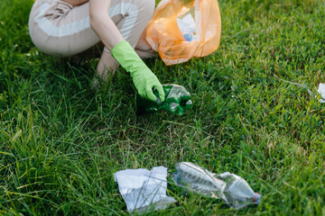 A group of girls with children at sunset are engaged in garbage collection in the park....