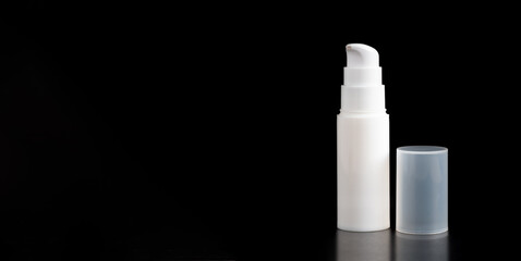 White bottle of cream or lotion isolated on black background.white shadows blur on the floor