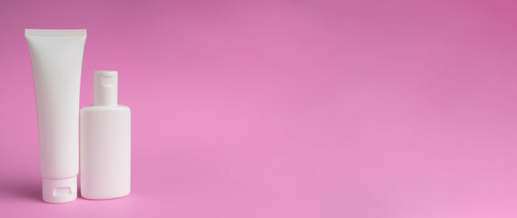 White Tube and bottle of lotion or cream isolated on pink background. Shadows blur on the floor
