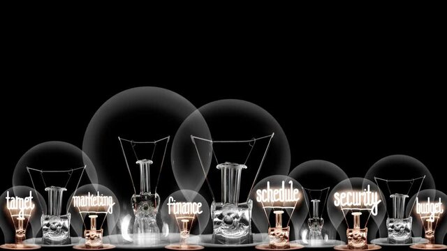Light bulbs going from dark to light with Event Management, Logistics, Target, Creativity and Media fiber text on black background. High quality 4k video.