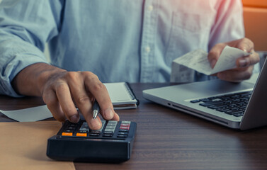 Accountant holding paper bills using calculator . Calculation Financial Budget Count Tax Vat Wage Concept