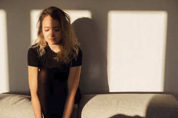 Sad asian young female sitting alone on sofa. Mental disorder. Anxiety or depression emotions,...