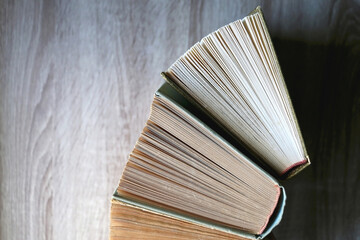 Naklejka premium Vintage hardcover books on a wooden table. Top view.