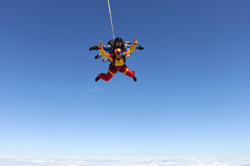 Fototapeta premium Skydiving. Tandem jump. A happy passenger and her instructor are flying in the sky.