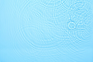 Transparent blue colored clear water surface texture with ripples, splashes and bubbles. Abstract...