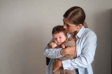 Attractive happy mother kiss holding little baby girl. Happy family