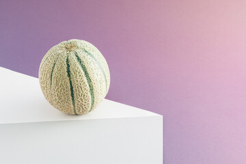 Creative layout made of melon on table against purple pastel background. Concept art. Minimal surrealism background. Summer fruit gravity concept.
