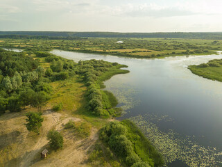 Fototapeta na wymiar Drone view of the beautiful landscape of the lake, fields, trees on a sunny evening before sunset