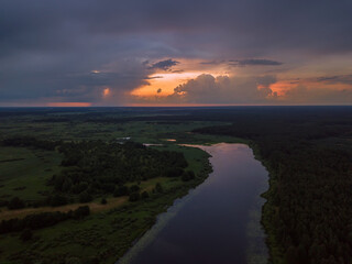 Fototapeta premium Beautiful, fascinating sunset with clouds over a lake, a river on a summer evening, view from a drone