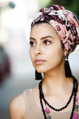Portrait of a beautiful Indian girl in scarf. Young hippie style woman wearing handmade jewelry