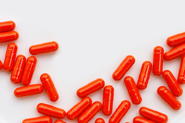 Orange capsule pills on white background.