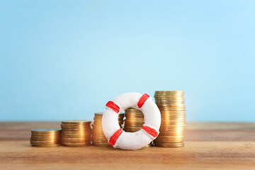 concept image of stacked coins and life bouy over wooden background. banking, funds and assistance...