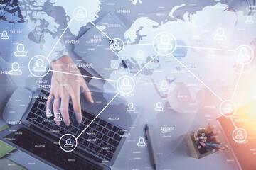 Double exposure of man's hands typing over computer keyboard and social network theme hologram drawing. Top view. People connection web concept.