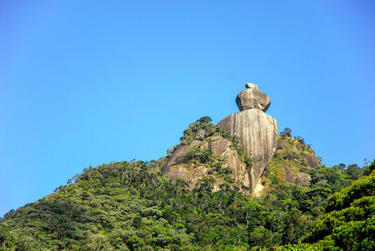 Pedra Peito do Pombo, famous rock formation on top of mountain surrounded by tropical forest, blue sky, Arraial do sana, Macae district, State of Rio de Janeiro, Brazil
