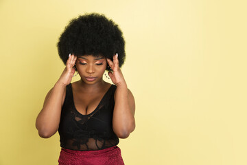 Portrait of African young woman isolated over light yellow studio background. Concept of human emotions, facial expression, youth, sales, ad.