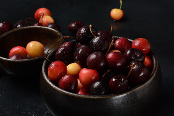 Yellow and red sweet cherries. Fresh ripe sour cherries. Fresh sweet cherries bowl  in water drops on stone background