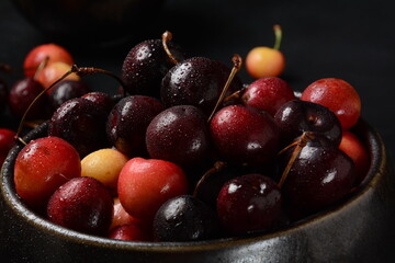 Yellow and red sweet cherries. Fresh ripe sour cherries. Fresh sweet cherries bowl  in water drops on stone background