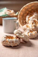 Brazilian sweet biscuit and a cup of coffee on a table with beige tablecloth, selective focus.