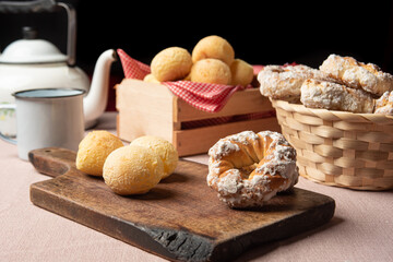 Brazil cheese bread and sweet biscuit and a cup of coffee on a table with beige tablecloth, selective focus.